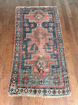 an antique caucasian kazak rug with a teal/blue field and large geometric medallions in a coral/terracotta tone 