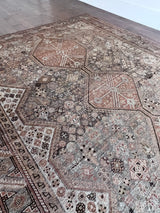 an antique qashqai rug with a greeny grey field and coral accents