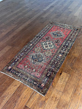 an antique heriz rug with a raspberry pink field and three pretty central medallions