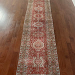 an antique heriz karajah runner with a dark coral field and icy blue and teal accents