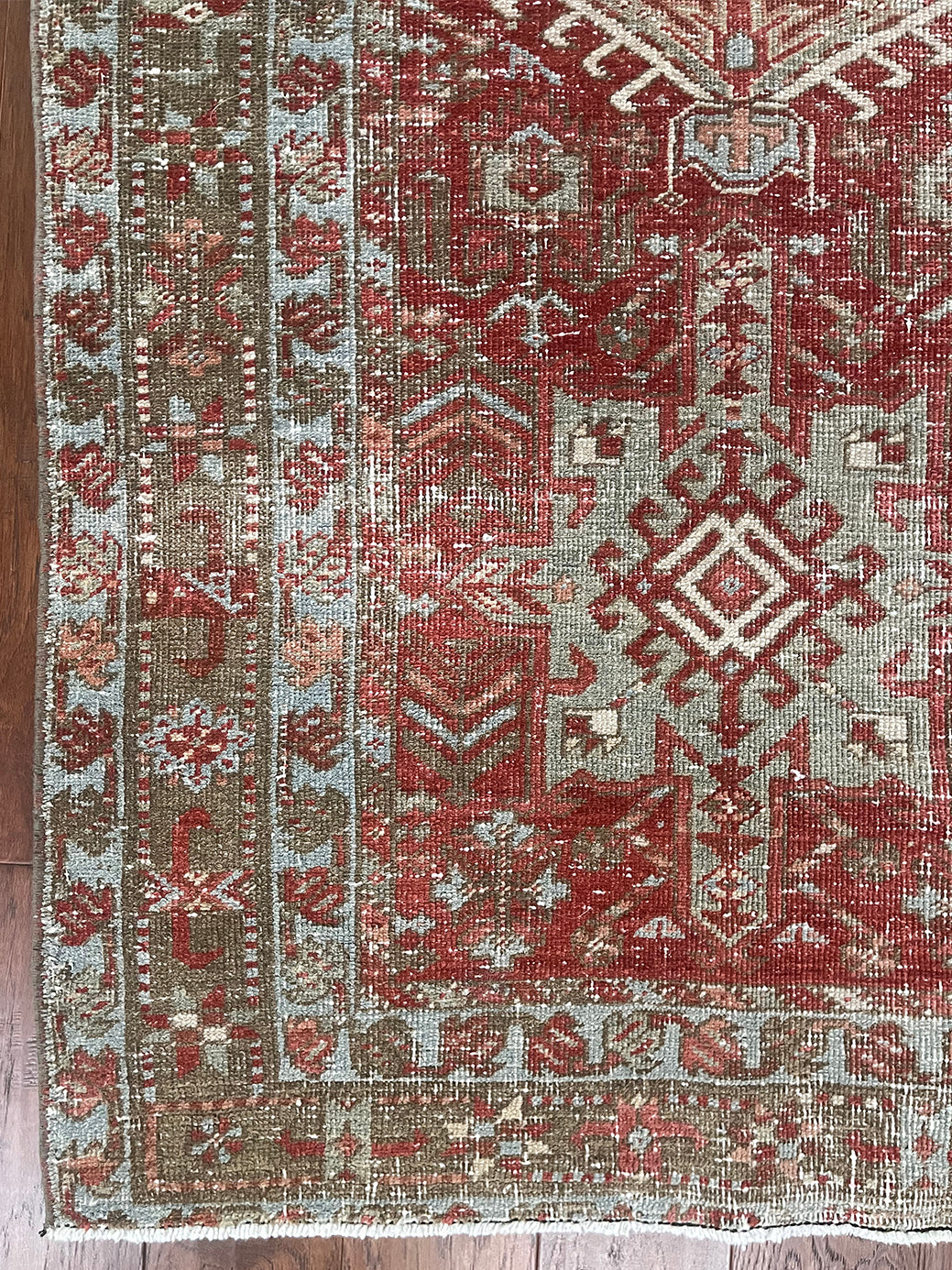 an antique heriz karajah runner with a dark coral field and icy blue and teal accents