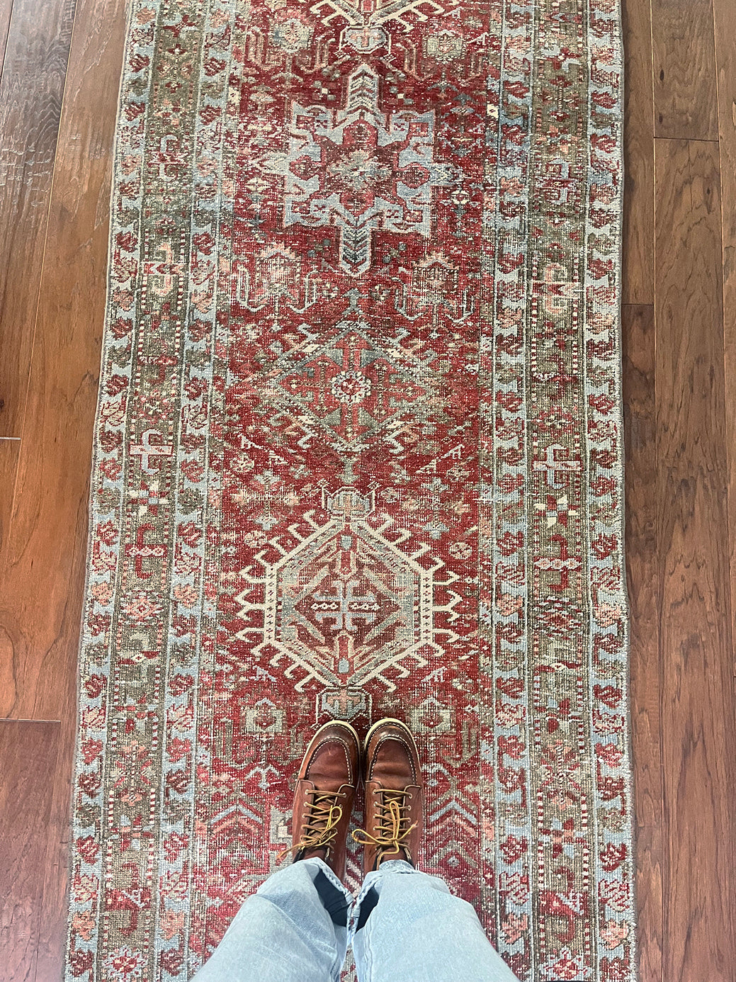an antique heriz karajah runner with a dark coral field and icy blue and teal accents