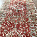 an antique heriz karajah runner with a dark coral field and icy blue and teal accents