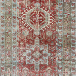 an antique heriz karajah runner with a dark coral field and icy blue and teal accents
