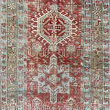 an antique heriz karajah runner with a dark coral field and icy blue and teal accents