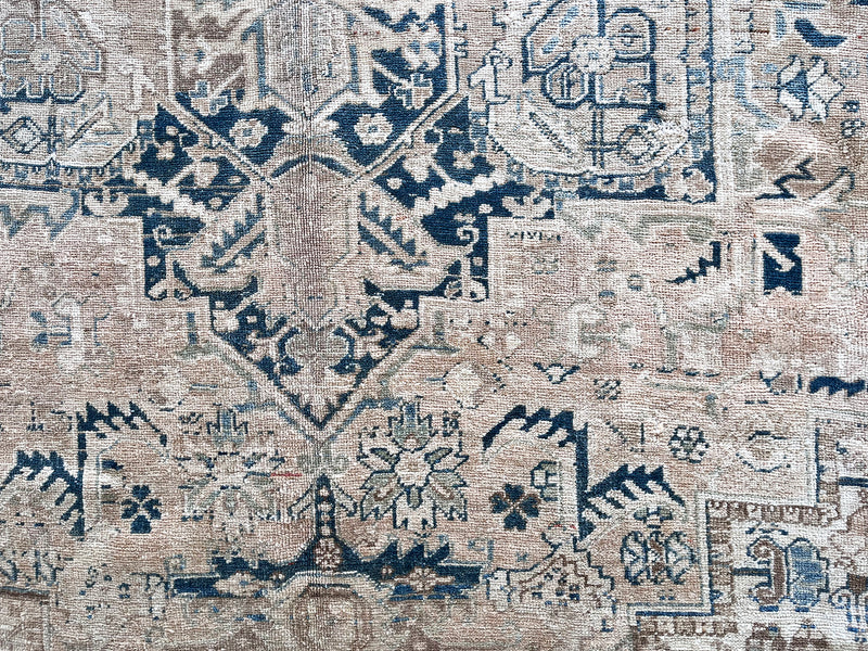 a large vintage heriz rug with a faded neutral palette, blue abrash and taupe accents 