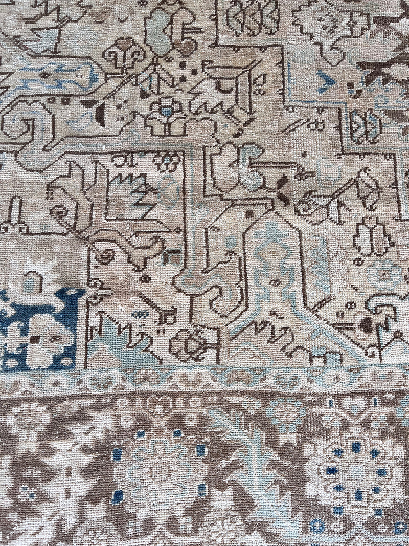 a large vintage heriz rug with a faded neutral palette, blue abrash and taupe accents 