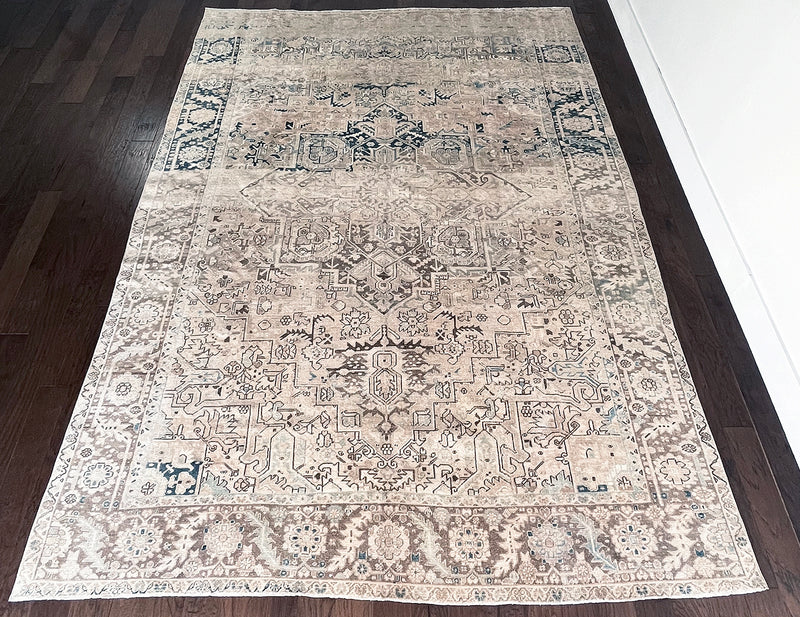 a large vintage heriz rug with a faded neutral palette, blue abrash and taupe accents 