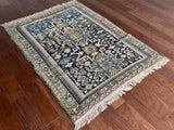 an antique caucasian rug with a blue palette and geometric pattern