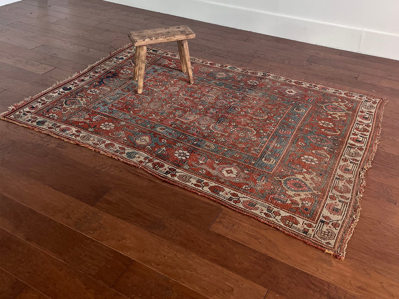 an antique kurdish rug with a brick red field and blue trellis pattern