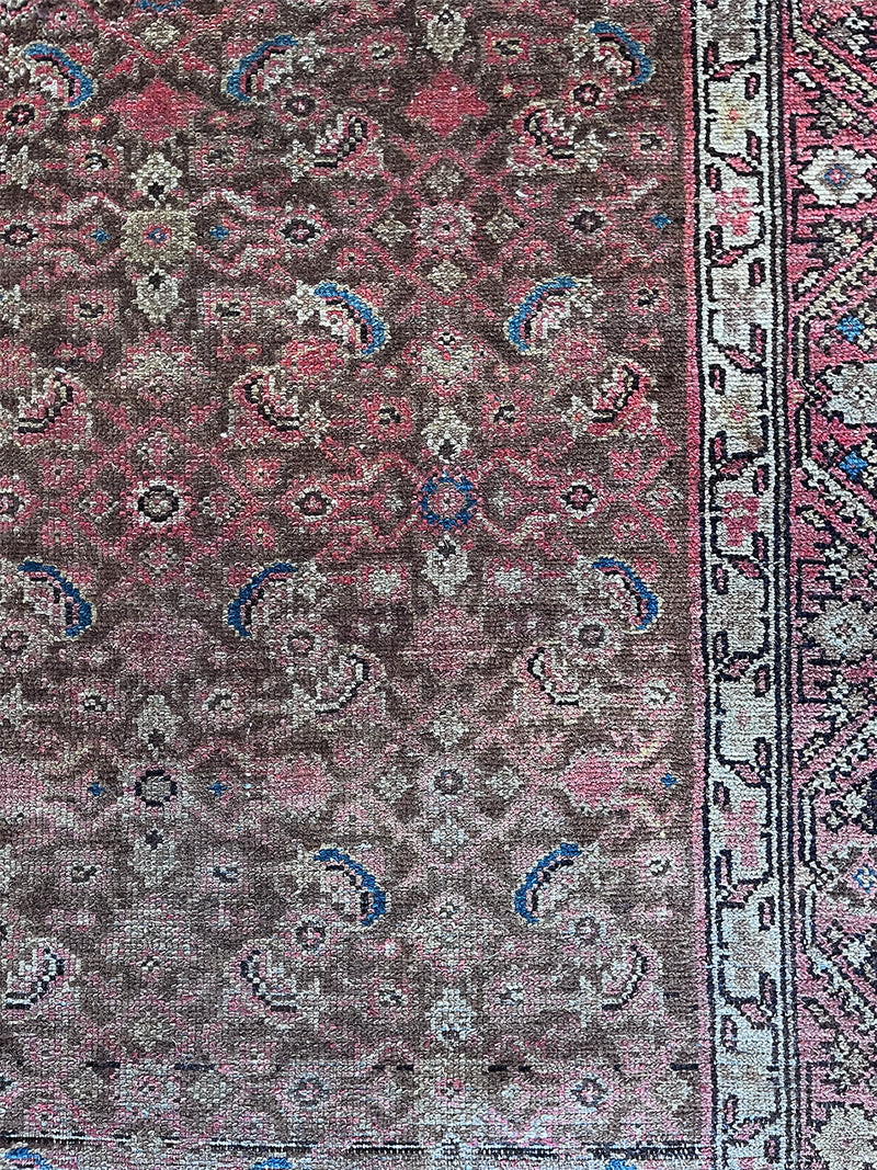 an antique malayer rug with a brown field and a pink trellis pattern