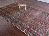 an antique malayer rug with a brown field and a pink trellis pattern