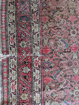 an antique malayer rug with a brown field and a pink trellis pattern