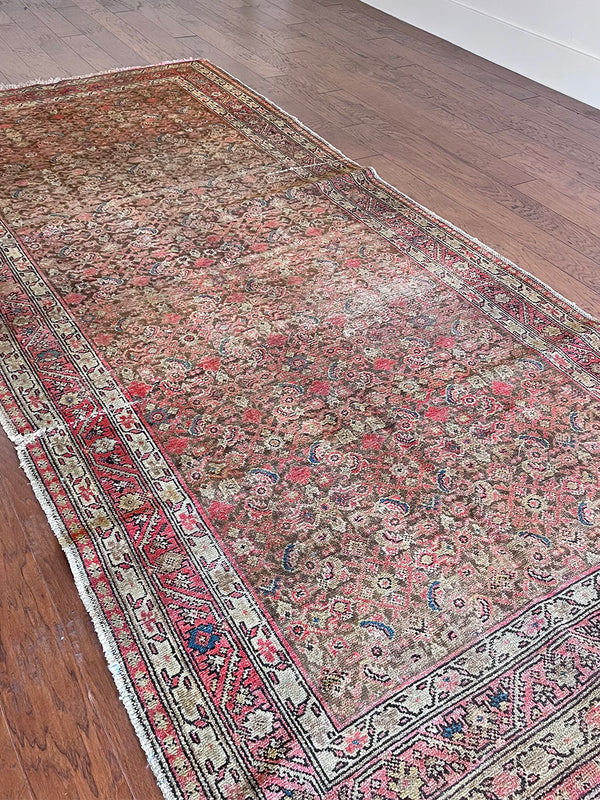 an antique malayer rug with a brown field and a pink trellis pattern