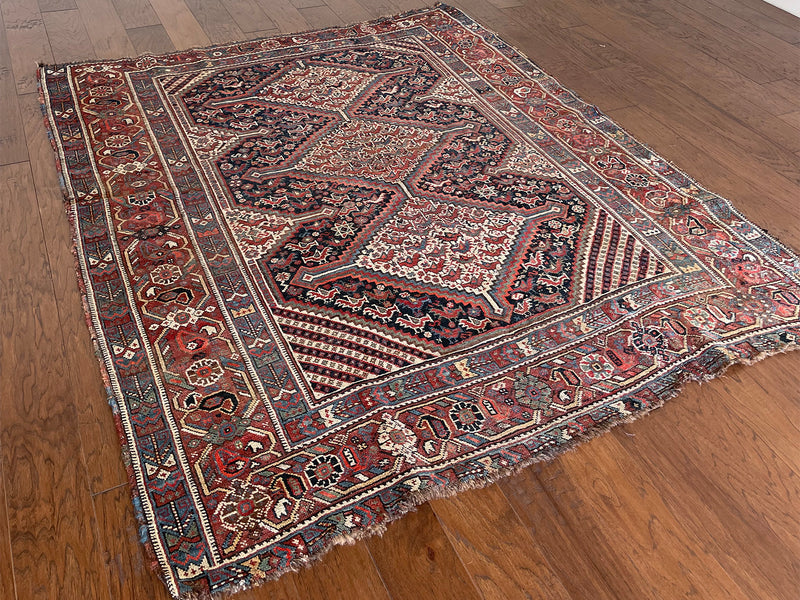 an antique qashqai rug with a pretty pin-stripe design and classic blue and red medallions