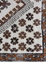 a vintage moroccan rug with a bright cream field and brown, orange and taupe accents