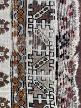 a vintage moroccan rug with a bright cream field and brown, orange and taupe accents