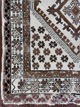 a vintage moroccan rug with a bright cream field and brown, orange and taupe accents