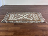 a vintage moroccan rug with a bright cream field and brown, orange and taupe accents