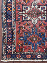 a mini vintage heriz karajah rug with a coral field and blue and white medallions