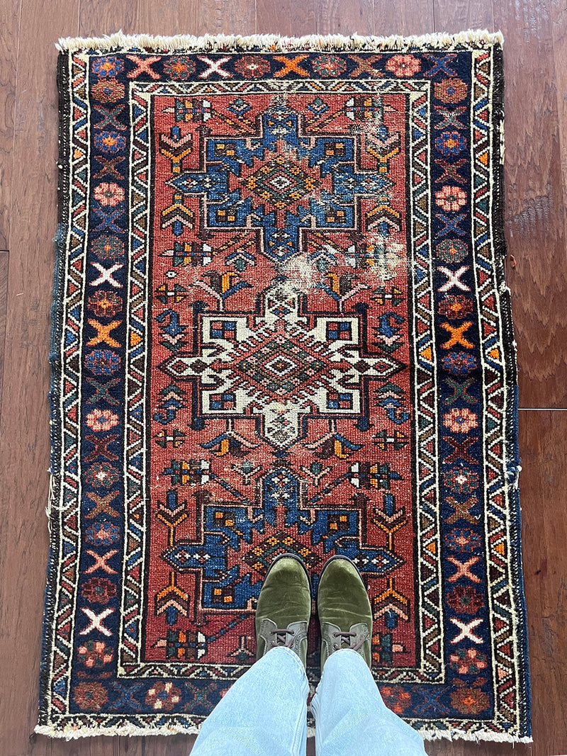 a mini vintage heriz karajah rug with a coral field and blue and white medallions