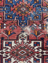 a mini vintage heriz karajah rug with a coral field and blue and white medallions