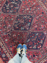 a vintage shiraz rug with a dark red field and dark blue medallions