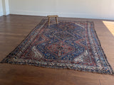 an antique qashqai rug with a beautiful navy blue field and a brick red border