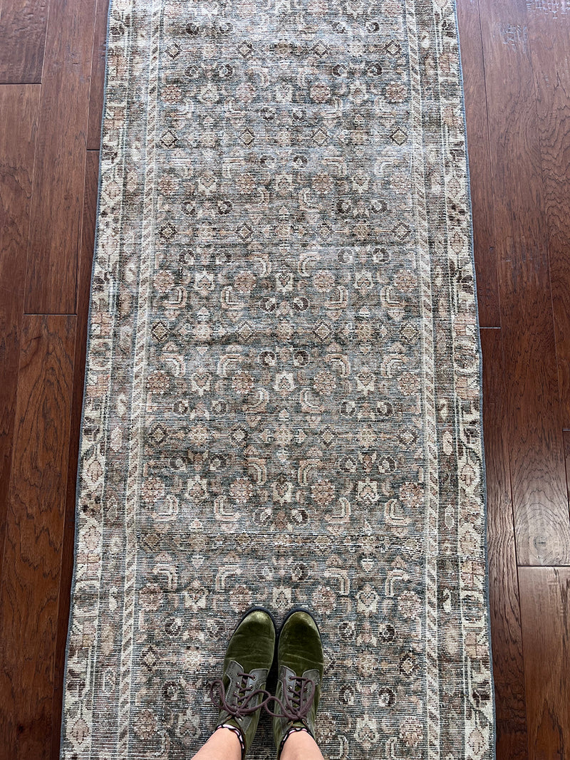 an antique malayer runner with a teal and taupe coloured palette and an intricate cream trellis pattern