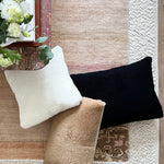 a black velvet pillow in shearling with a plush velvet backing and exposed brass zipper