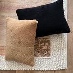 a black velvet pillow in shearling with a plush velvet backing and exposed brass zipper