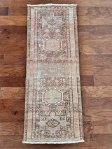 a vintage heriz runner with soft pink undertones, light turquoise and icy blue hues