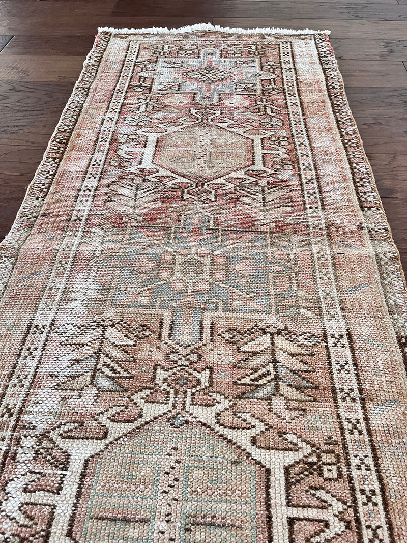 a vintage heriz runner with soft pink undertones, light turquoise and icy blue hues