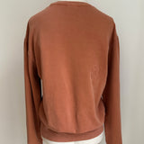 a comfy easy to wear sweatshirt in wam terracotta with 'vintage' embroidered upside down for an abstract look