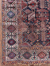 an antique qashqai rug with a midnight blue field and white, yellow and red accents 