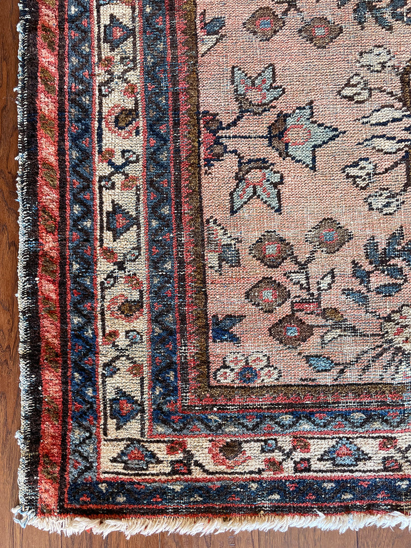 an antique mahal rug with a soft pink field and a pretty blue and brown floral pattern