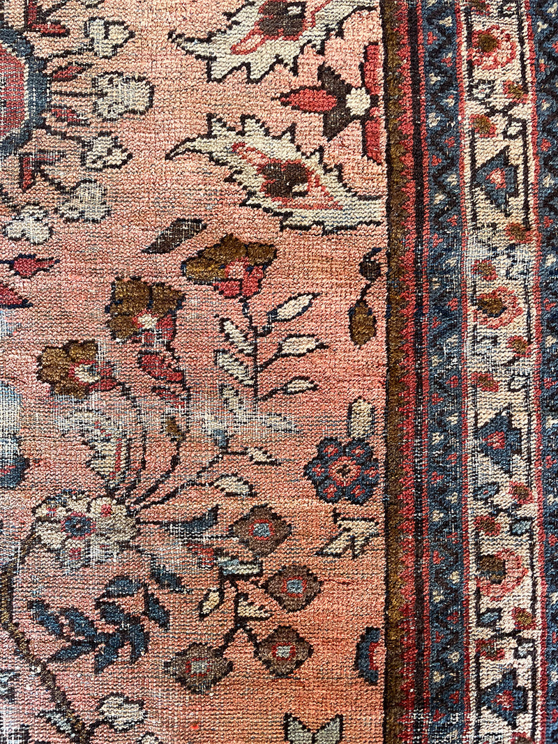 an antique mahal rug with a soft pink field and a pretty blue and brown floral pattern