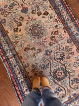 an antique mahal rug with a soft pink field and a pretty blue and brown floral pattern