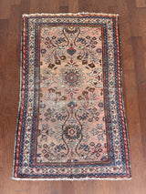 an antique mahal rug with a soft pink field and a pretty blue and brown floral pattern