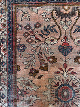 an antique mahal rug with a soft pink field and a pretty blue and brown floral pattern