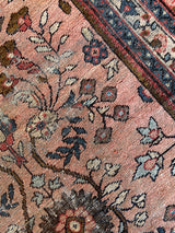 an antique mahal rug with a soft pink field and a pretty blue and brown floral pattern