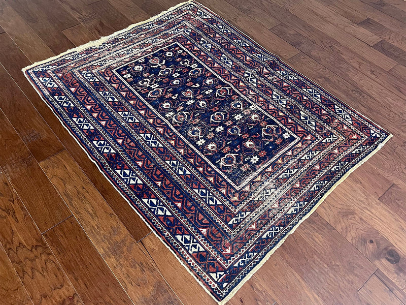 an antique caucasian shirwan rug with a navy blue field and a red border