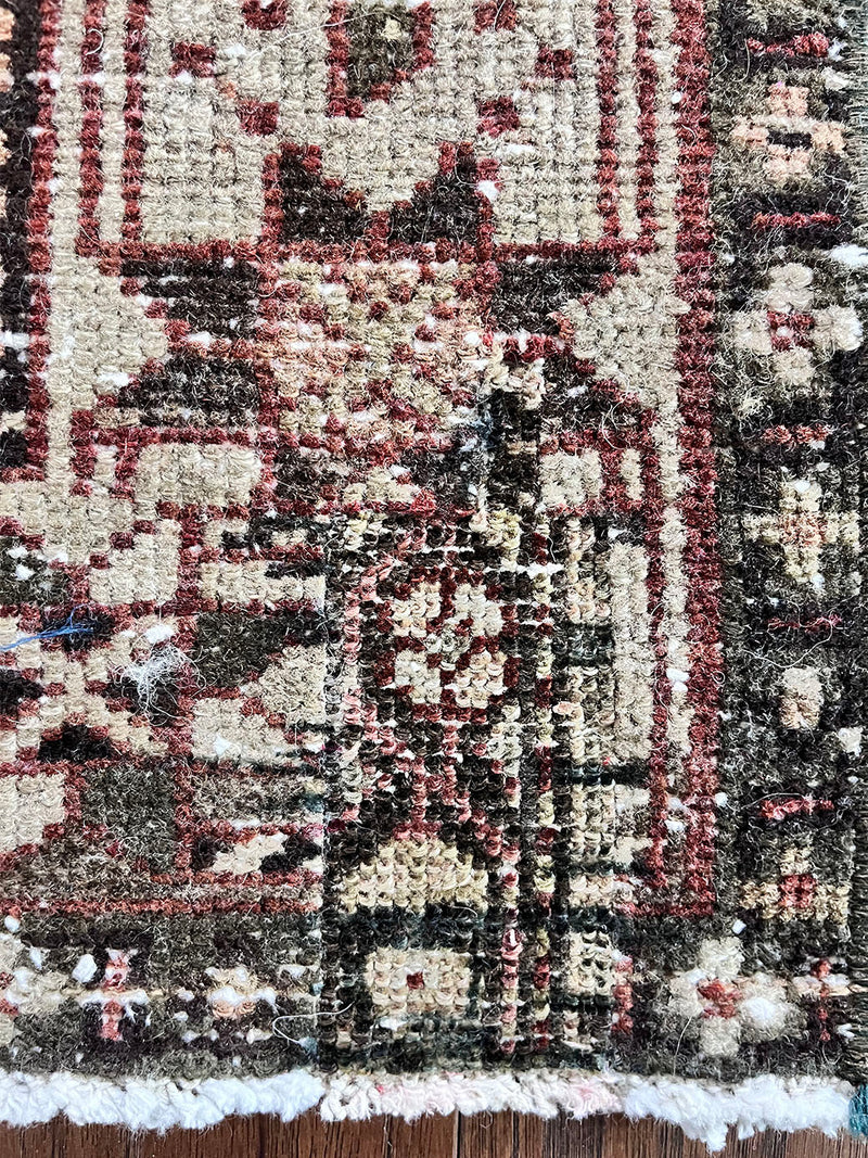 an antique heriz karajah runner with a deep wine red and brown palette and light pink and yellow accents