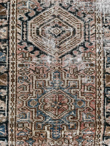 a vintage heriz runner with soft blush undertones and dark blue and brown accents
