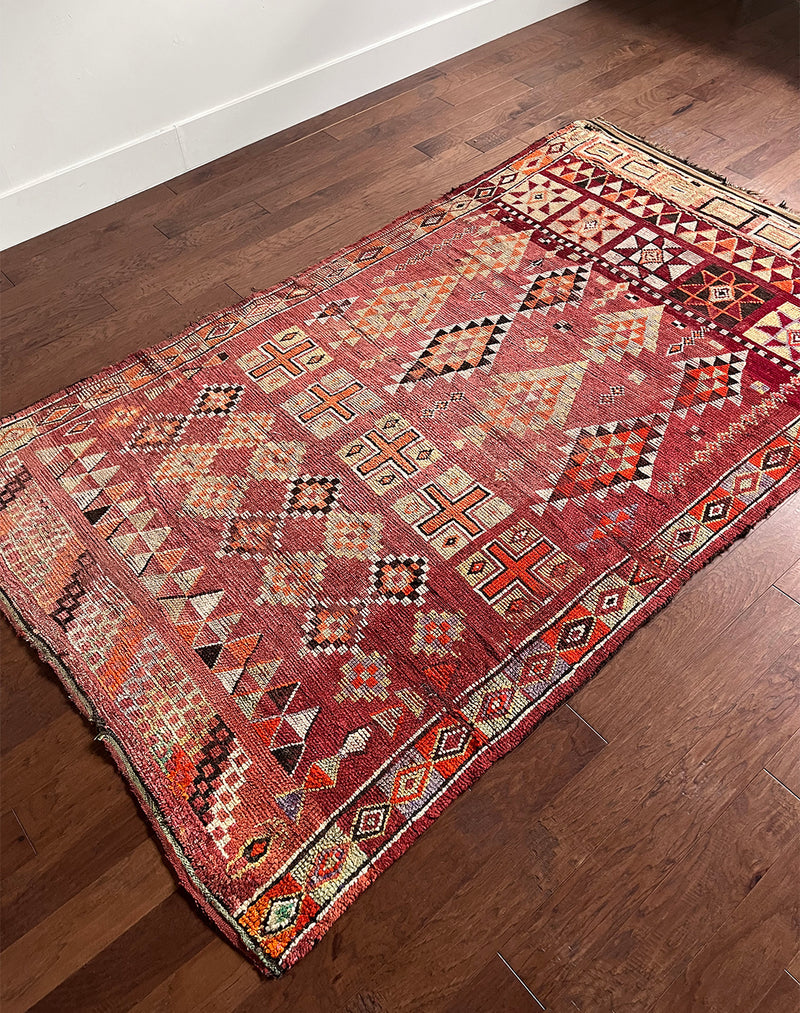 a vintage moroccan rug with a cherry red and pink palette and pretty lilac accents