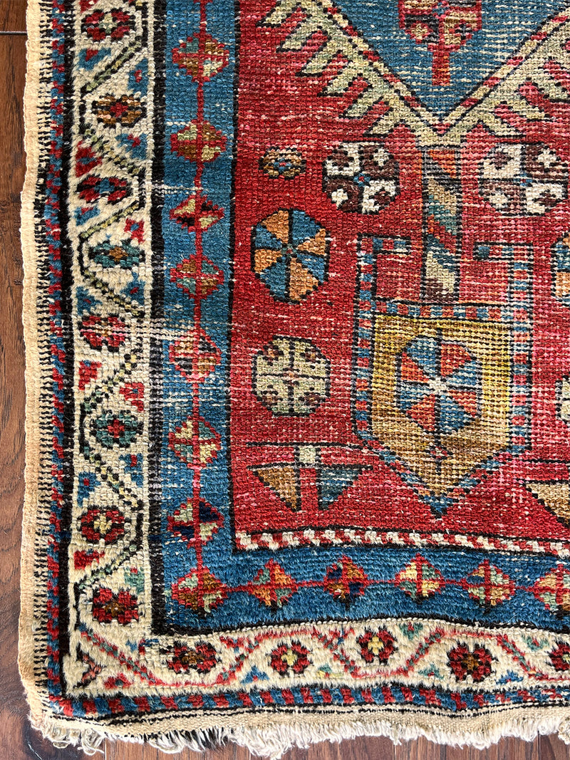 an antique heriz runner with a red field and blue, green and mustard medallions