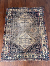 an antique afshar rug with a dark blue and ivory palette and pretty coral accents