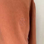 a comfy easy to wear sweatshirt in wam terracotta with 'vintage' embroidered upside down for an abstract look