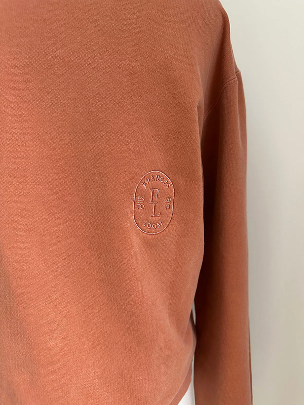 a comfy easy to wear sweatshirt in wam terracotta with 'vintage' embroidered upside down for an abstract look