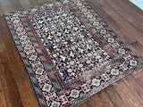 an antique caucasian shirwan rug with a dark blue field and a geometric pattern in cream